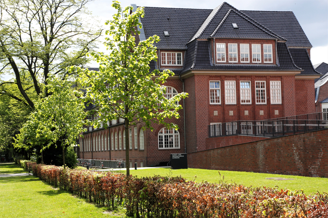 Campus Finkenau im Frühling. Sonnenschein, grünes Gras und grüne Bäume.