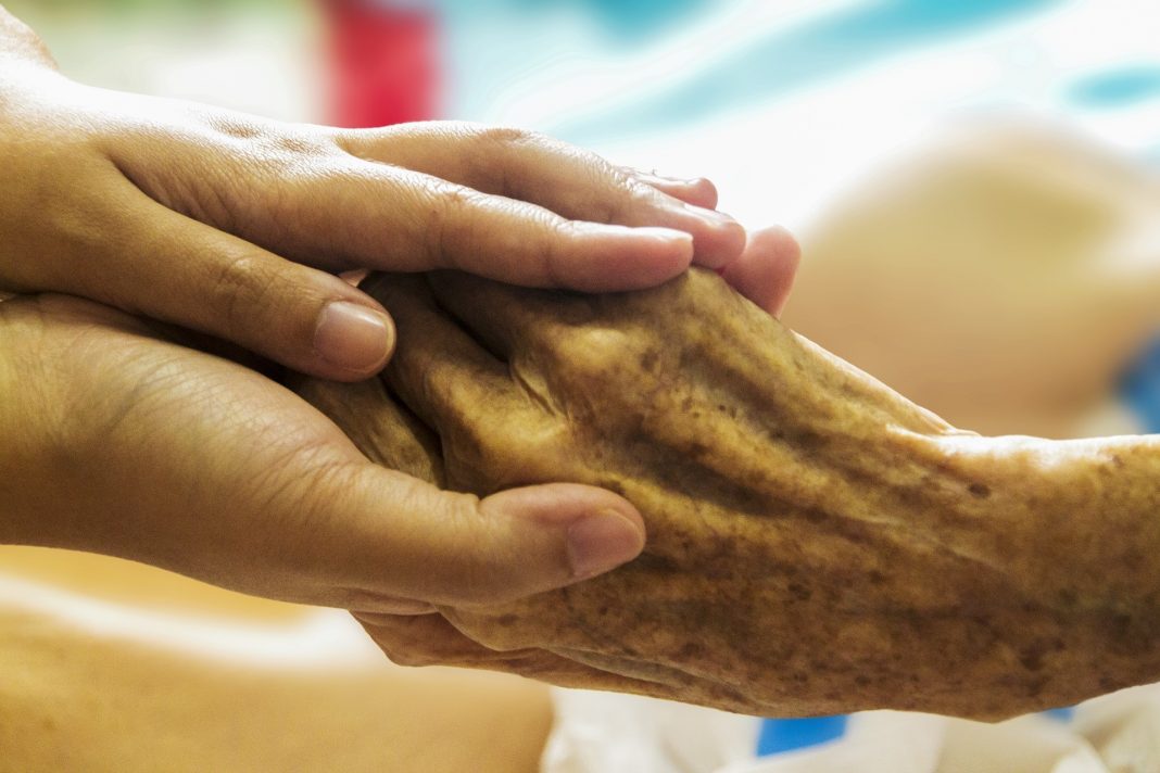 Die Hand eines älteren Menschen wird gehalten.