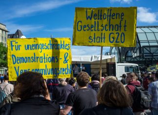 10.000 Unterschriften gegen G20 Demonstranten am Hachmannplatz halten Schilder hoch. Die Volkspetition ist erfolgreich.