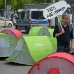 “Hecken schützen statt Heckenschützen!” Ein G20-Gegner läuft am 13.05.2017 in Hamburg auf dem Karolinenplatz mit einem Schild mit der Aufschrift «Yes we camp» an Zelten entlang. Der Bezirk Hamburg Nord kann das geplante Camp der Gegner des G20-Gipfels im Stadtpark nicht verbieten.
