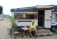 “Merkel finde ich scheiße” Parkplatzwächter Ayax vor seinem Wohnwagen. Foto: Lesley-Ann Jahn