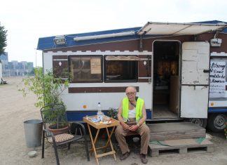 “Merkel finde ich scheiße” Parkplatzwächter Ayax vor seinem Wohnwagen. Foto: Lesley-Ann Jahn