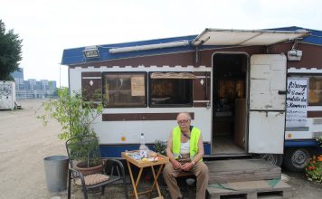 “Merkel finde ich scheiße” Parkplatzwächter Ayax vor seinem Wohnwagen. Foto: Lesley-Ann Jahn