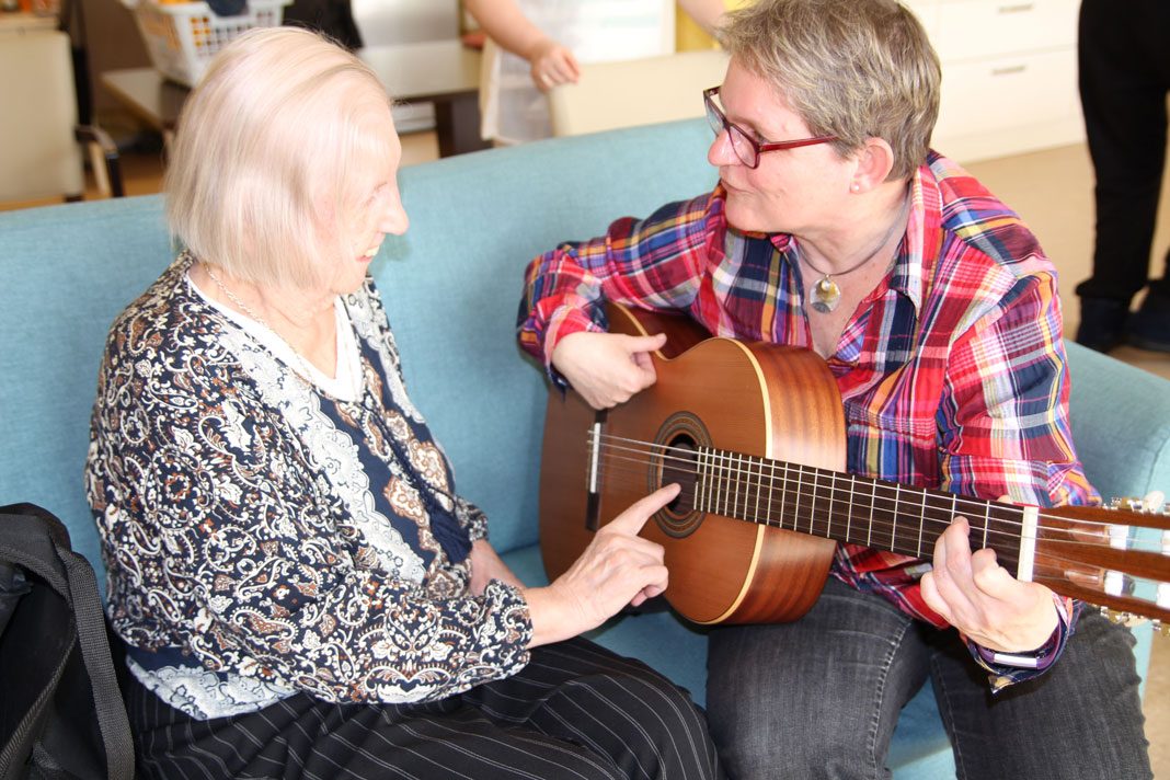 Demenz-Patientin spielt Gitarre bei der Musikpatin Susanne Buse.