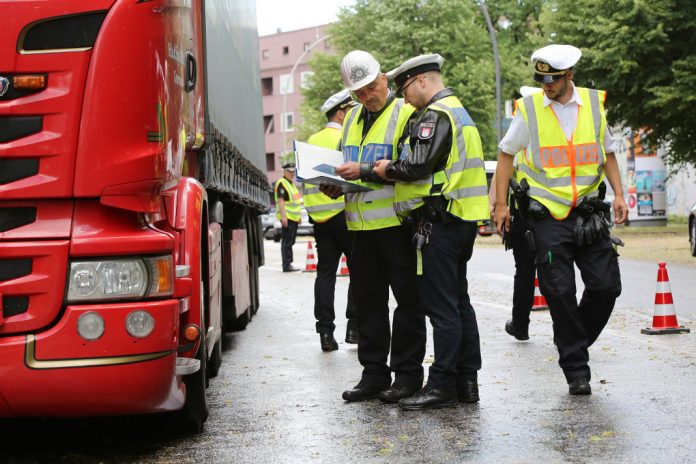 Polizisten kontrollieren in der Plöner Straße einen Lastwagenfahrer auf die Einhaltung des Dieselfahrverbotes