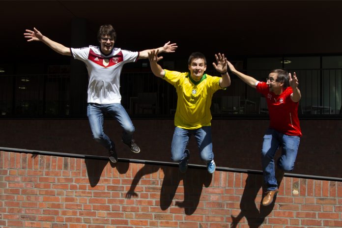 Die WM-Podcast-Moderatoren Tobi, Ted und Björn springen im Schweden und Mexiko-Trikot voller WM-Frust von einer Mauer.