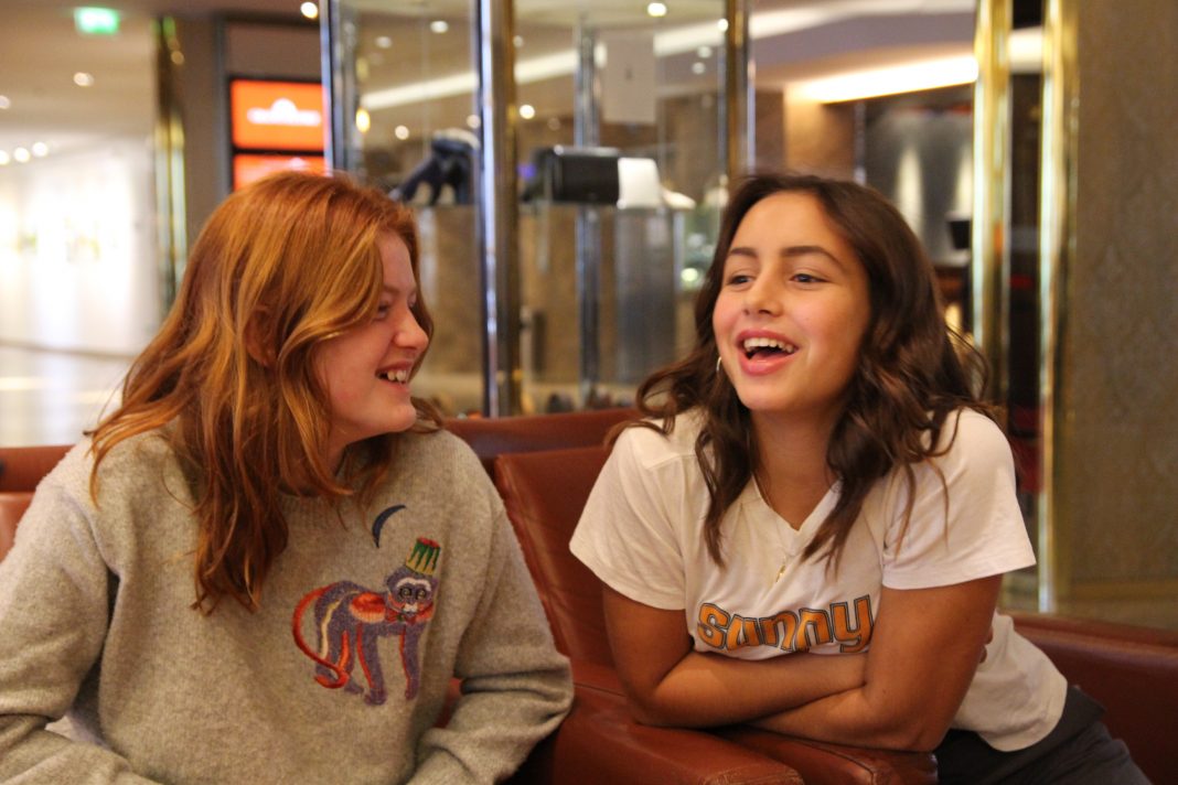 Die beiden Jungschauspielerinnen aus Dänemark haben sich durch die Dreharbeiten für Wildhexe angefreundet. Man sieht beide jungen Mädchen lachend nebeneinander sitzend.