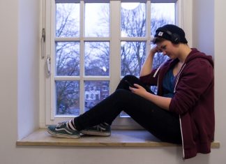 Charts 2018: Das sind unsere Top-Tracks Person hört Streaming Dienste Charts im Fenster.