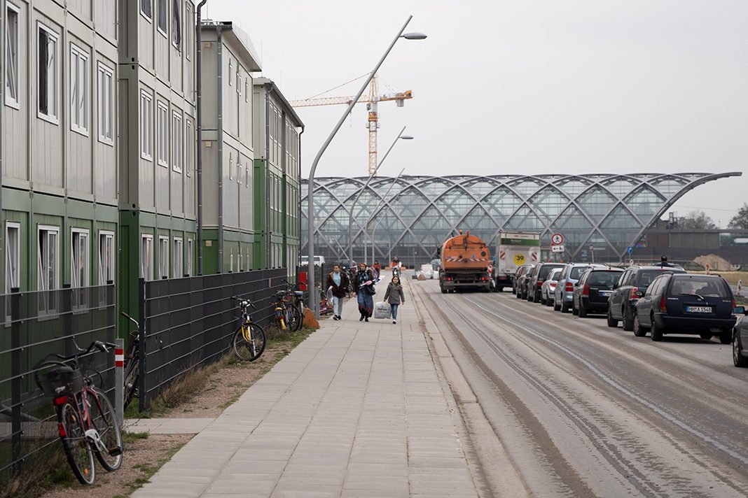 Menschen gehen von der S-Bahnstation Elbbrücken zum Flüchtlingsheim