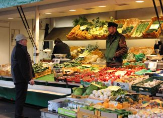 Lebensmittellabyrinth unter der U-Bahn Ernst Prigge unterhält sich mit einem Kunden an seinem Obst- und Gemüsestand auf dem Isemarkt