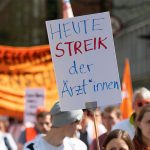 Warnstreik: 2.000 Ärzte gehen in Hamburg auf die Straße Eine Frau trägt ein Plakat mit der Aufschrift "Heute Streik der Ärzt*innen".