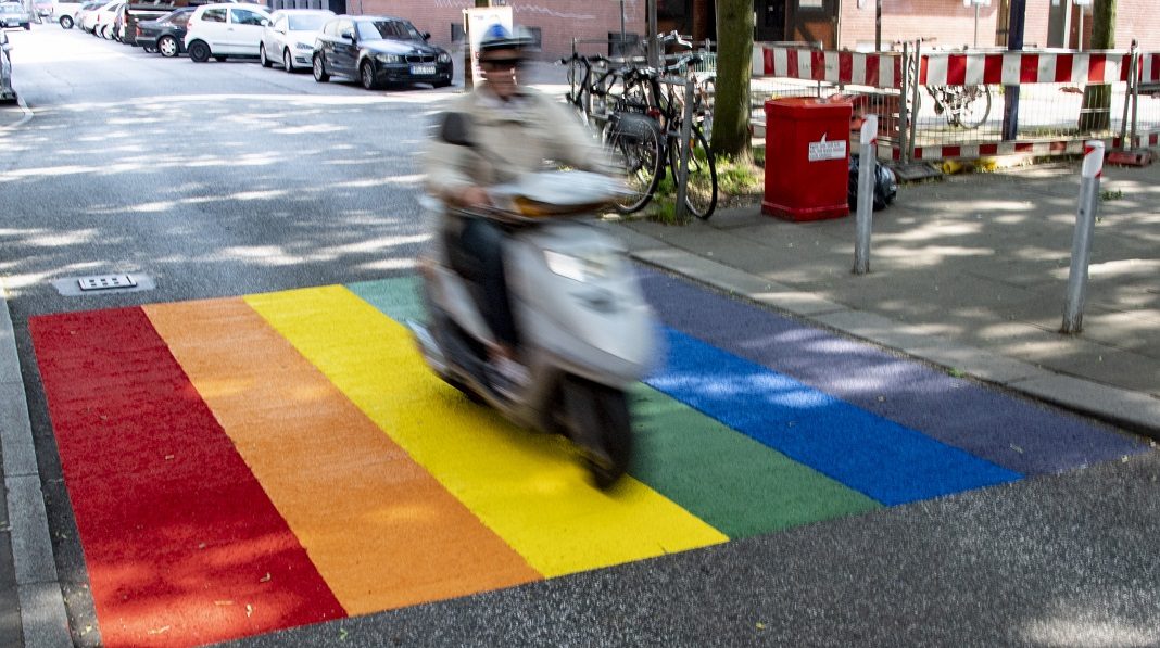 Ein Roller passiert eine neue Regenbogen-Markierung im Hamburger Stadtteil St. Georg.