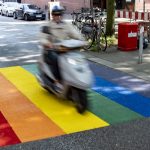 Werden die Regenbogenstreifen in St. Georg verboten? Ein Roller passiert eine neue Regenbogen-Markierung im Hamburger Stadtteil St. Georg.
