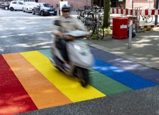 Werden die Regenbogenstreifen in St. Georg verboten? Ein Roller passiert eine neue Regenbogen-Markierung im Hamburger Stadtteil St. Georg.