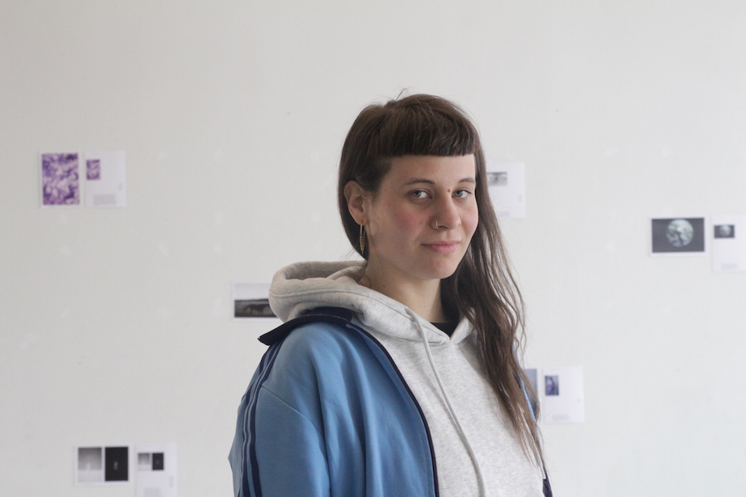 Absolventin Sofia Mintre steht vor ihrer Fotoausstellung.