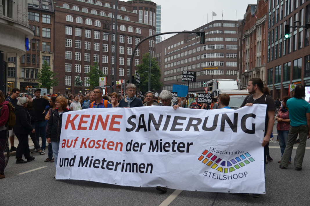 Menschen halten auf einem Demonstrationszug ein Banner mit der Aufschrift "Keine Sanierung auf Kosten der Mieter und Mieterinnen" vor sich her.