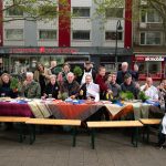 Gemeinsam Futtern in Altona Die Kooperationspartner des Kulturfutters posieren an einer aufgebauten Essenstafel in Altona