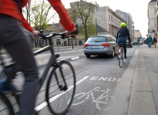 Fahrradstadt? Immer mehr Autos in Hamburg Zwei Radfahrer und ein Auto auf einer Straße. Der Radweg ist zu Ende.