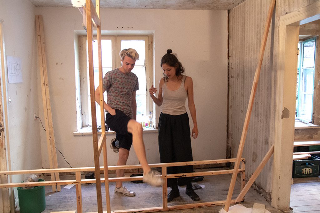 Lisa und Andreas stehen vor einer Holzkunstruktion im Museum im Gängeviertel.