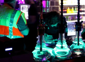 Nächtliche Großrazzia in 80 Hamburger Shisha-Bars Zollbeamter hinter drei beleuteten Shishas.