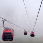 Mit Gondeln über den Stau schweben Gondeln im Nebel in den Alpen