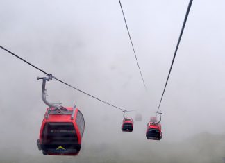 Mit Gondeln über den Stau schweben Gondeln im Nebel in den Alpen