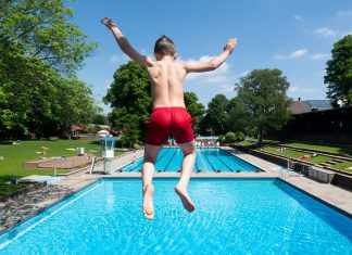 Was ihr jetzt zur Öffnung der Freibäder wissen müsst Endlich: Die Freibäder öffnen wieder! Ein Junge springt bei sonnigem Wetter im Kaifu-Bad vom Sprungturm.