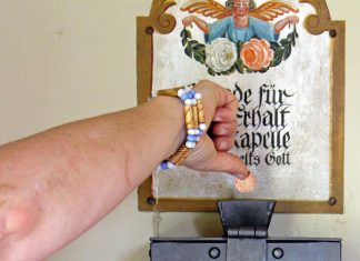 Schüler*innen sammeln Spenden für den Erhalt ihrer Schule Eine Hand, die Geld in einen Opferstock wirft,