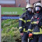 Vier Verletzte bei Brand im UKE Zwei Feuerwehrleute stehen vor dem UKE in Hamburg.