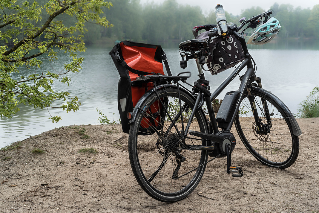 Ein E-Bike steht an einem See.