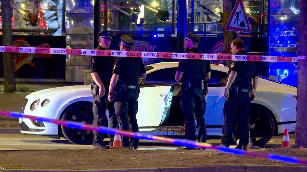 Polizisten stehen neben einem Auto eines Hells-Angels-Boss auf dem Millerntorplatz an der Reeperbahn.