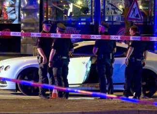 Schüsse auf Hells-Angels-Boss: Lange Haftstrafen für Paar Polizisten stehen neben einem Auto eines Hells-Angels-Boss auf dem Millerntorplatz an der Reeperbahn.