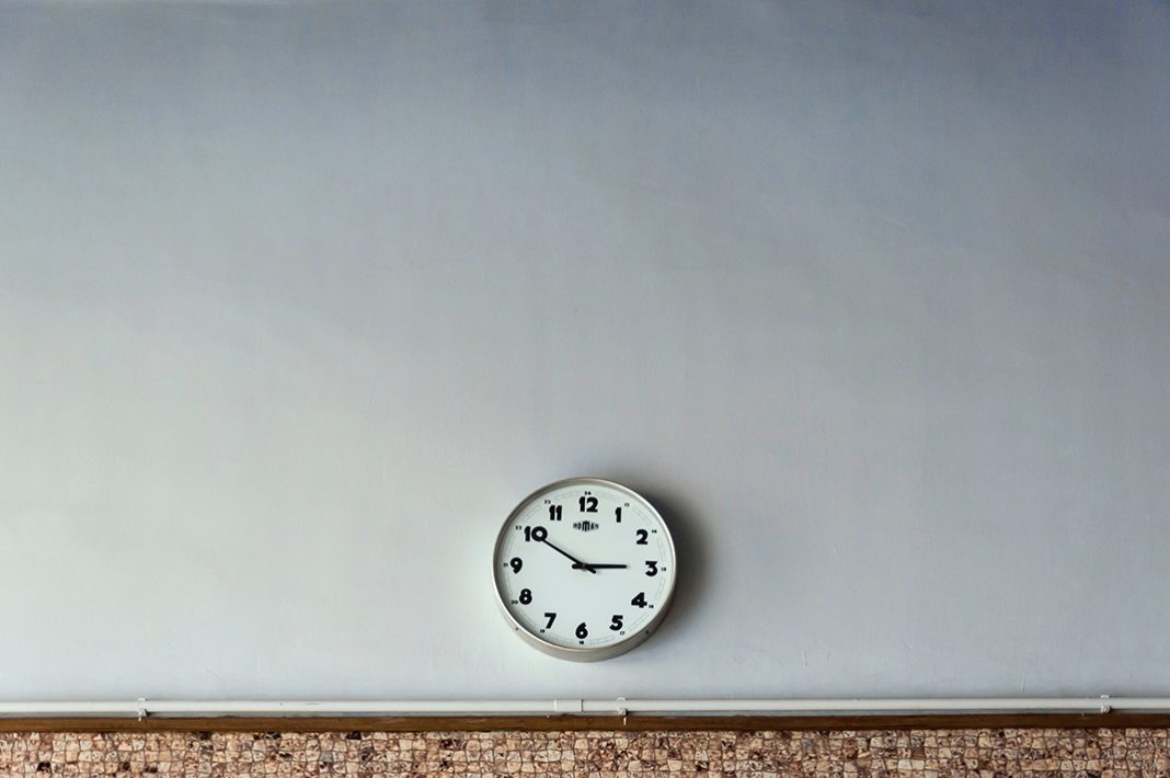 Große graue Wand mit einer analogen Uhr