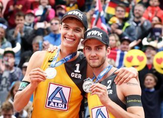 Beachvolleyball-WM: Deutsches Team holt Silber Beachvolleyball-Vizemeister Julius Thole und Clemens Wickler mit ihren Silbermedaillen, im Hintergrund feiernde Fans