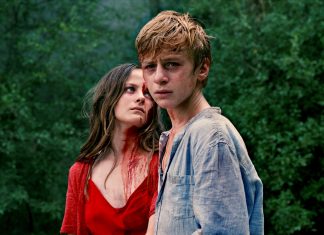 Road-Trip in den Wahnsinn Gloria steht mit starrem Blick und blutverschmiertem Gesicht neben Paul.