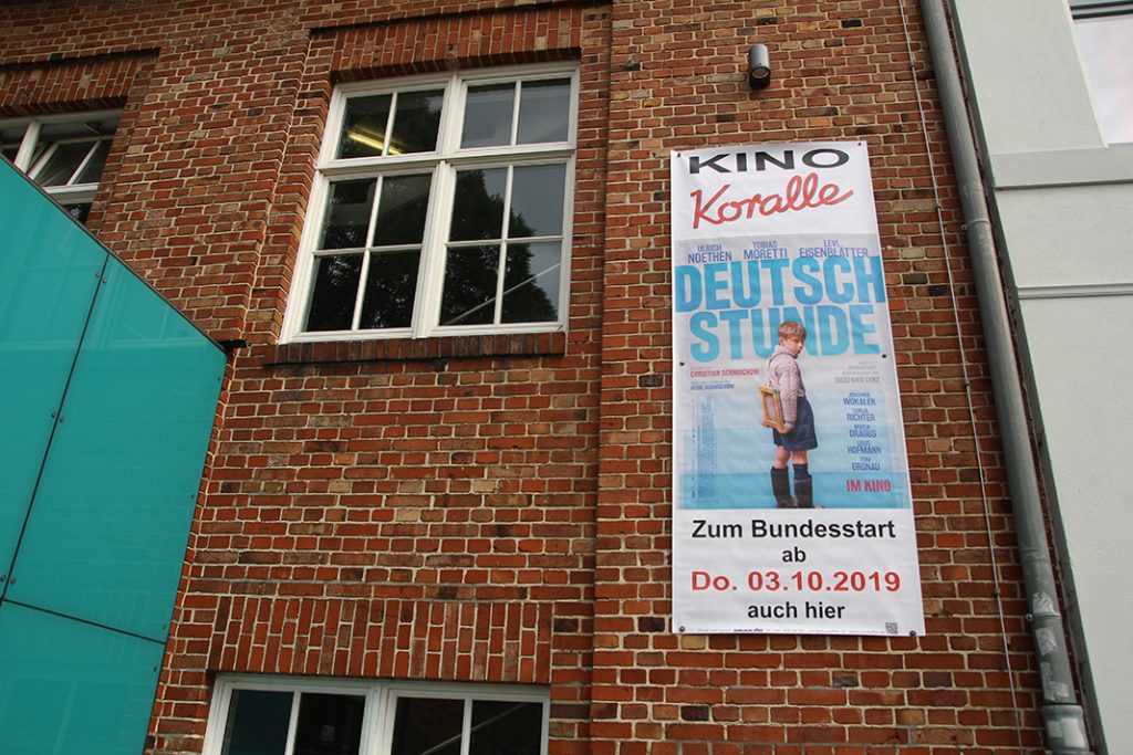 Werbepßlakat für den Film "Deutschstunde" an der Hauswand des Koralle Kinos