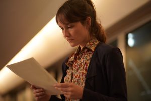 Eine junge Frau hält Notizen in der Hand. Filmstill aus "Alice and the Mayor".