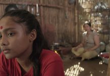 “Die Dreharbeiten haben neun Jahre gedauert” Ein hinduistisches Mädchen sitzt in einer Bambushütte, im Hintergrund unscharf die Mutter