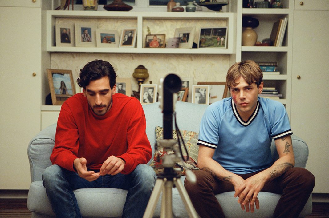 Matt und Max sitzen auf einem Sofa und schauen in die Kamera