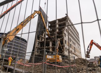 Abriss mit Spezialbagger Blick durch den Bauzaun: Block A des City-Hofs wurde schon zu einem Teil abgebrochen. Foto: Benjamin Eckert