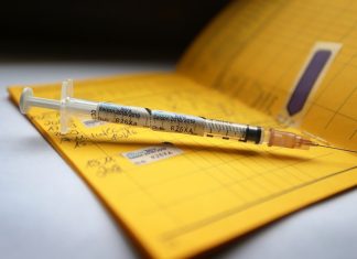 Hamburger Impfwoche gestartet Eine Spritze die mit dem Namen des Vierfach-Grippeimpfstoff Influvac Tetra gekennzeichnet ist, liegt auf einem Impfpass.