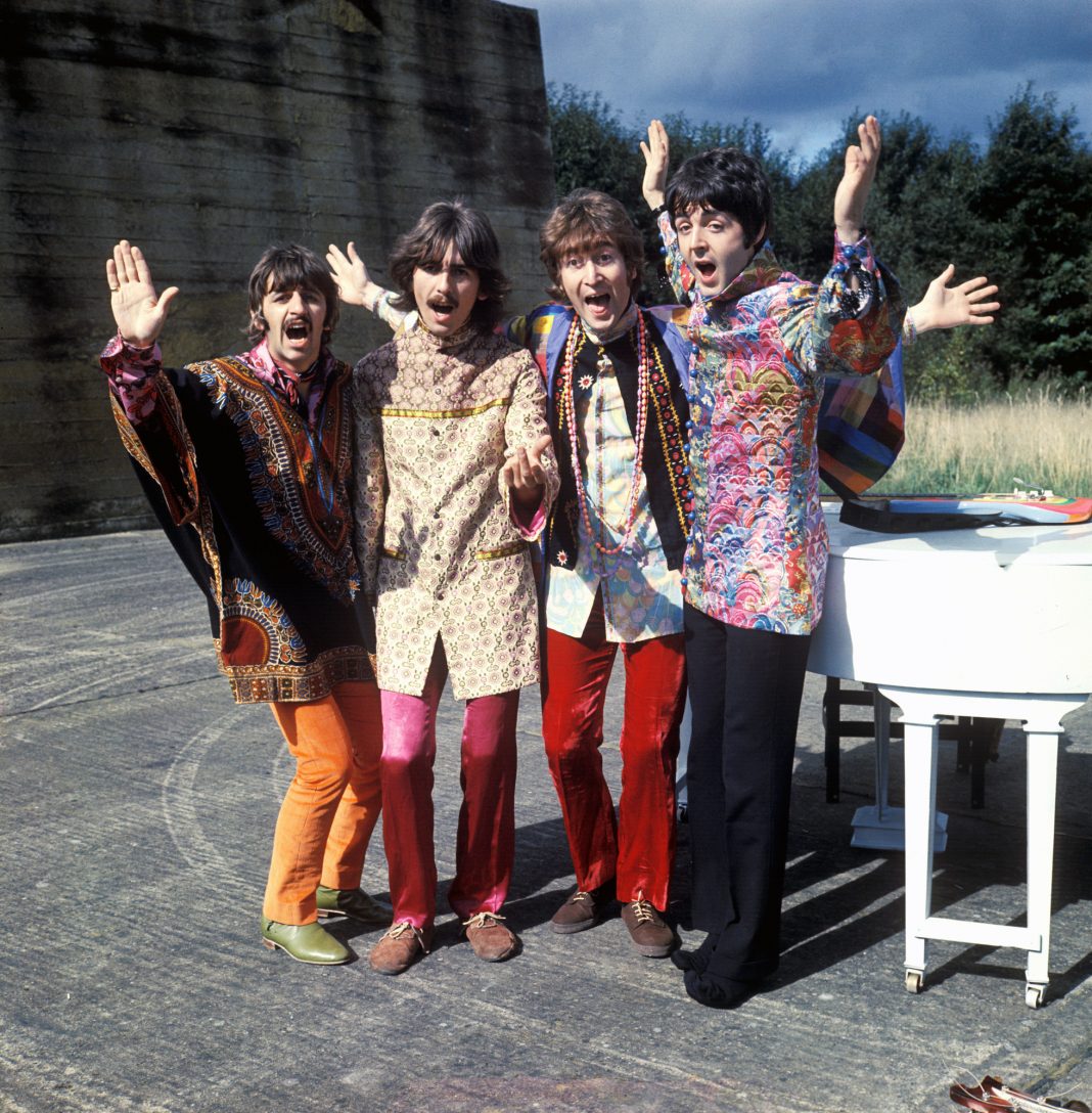 Die Beatles in schrillen Gewändern am Feiern.