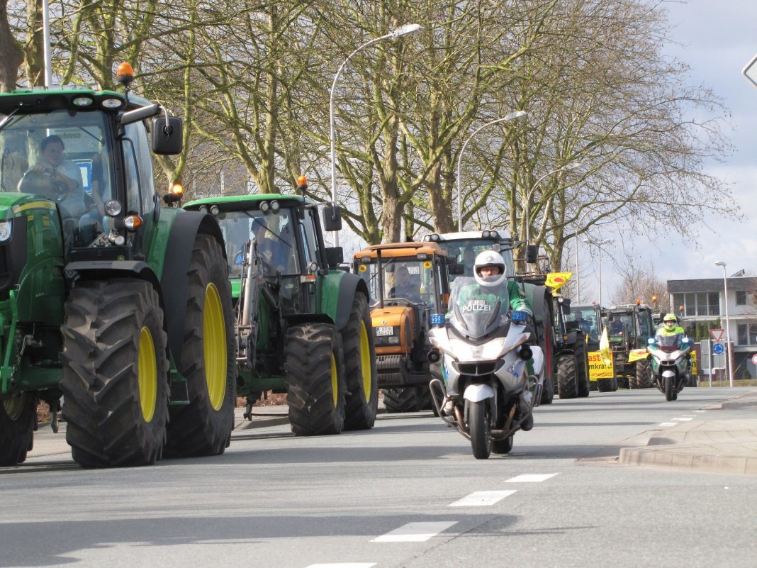 Traktorenkolonne werden von Polizisten auf Motorrädern begleitet.