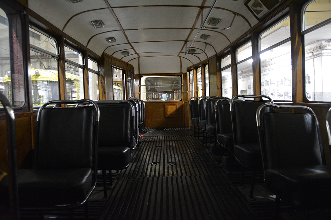 An old tram wagon in a museum in Saint Petersburg. The chairs are made from black leather.
