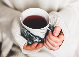 Glühwein gegen Klamottenspende Zwei Hände halten eine Tasse mit einer Flüssigkeit.