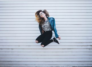 Glück ist in Hamburg jung und reich Eine Frau sprint hoch und zieht die Beine an.