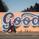 Kein Platz für Sexismus und Rassismus in Graffitis Ein Mann geht vor einer Wand mit Graffiti entlang.