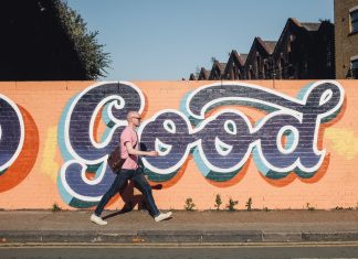 Kein Platz für Sexismus und Rassismus in Graffitis Ein Mann geht vor einer Wand mit Graffiti entlang.
