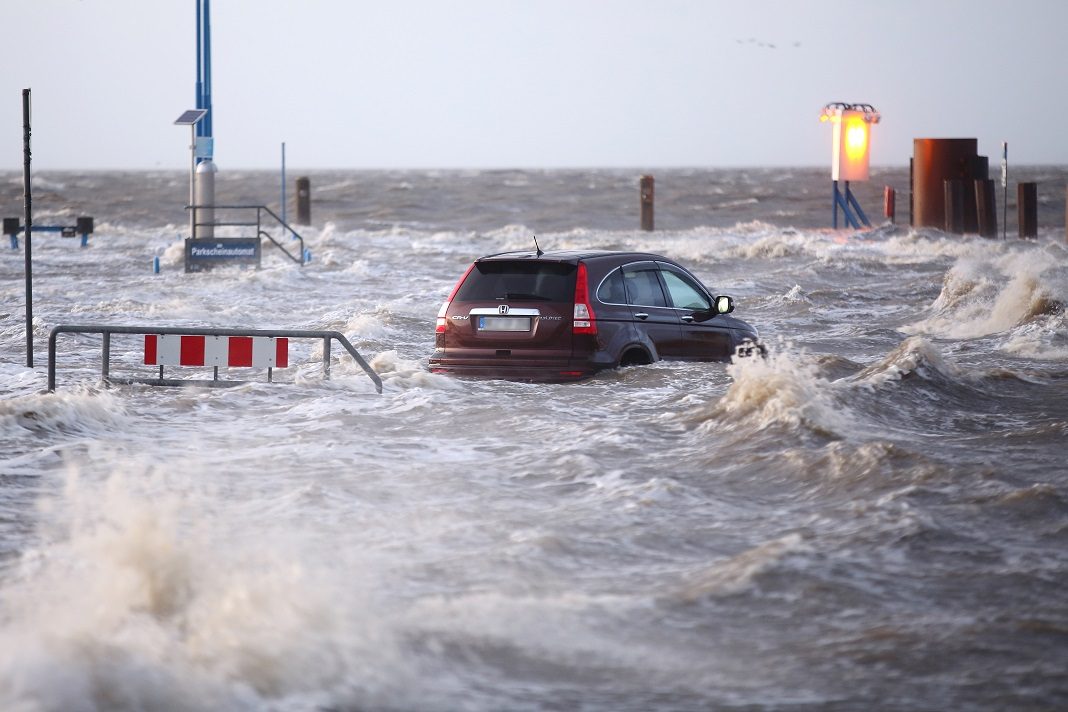 Ein Auto steht während des Sturmtiefs Wilfried bis über die Reifen im Wasser.