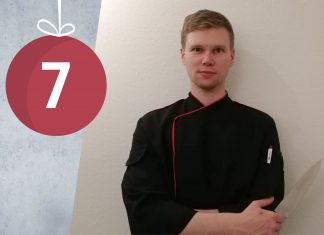 “Weihnachten bedeutete für mich viel Arbeit und wenig Küchenromantik” Kevin Schmidt steht mit einem Messer in der Hand vor einer weißen Wand.